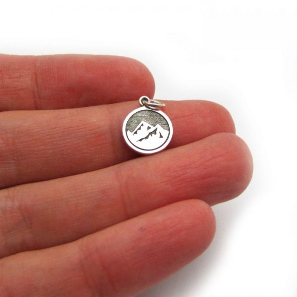 earth element tag front of charm sterling silver in hand to show scale