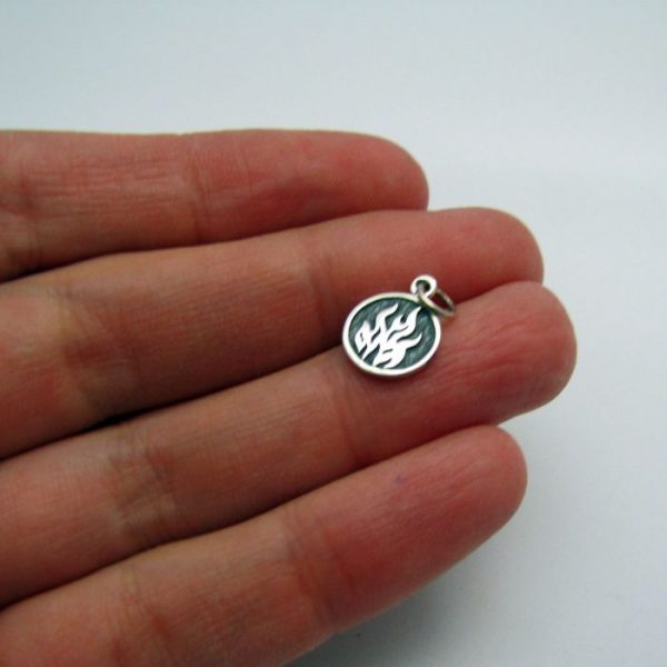 fire element tag front of charm sterling silver in hand to show scale