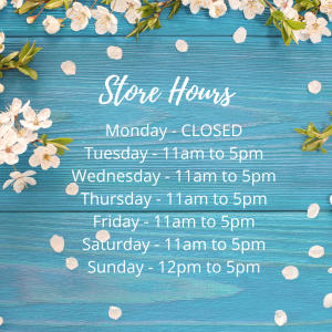 Image shows a blue wood textured background with Cherry blossoms around the side. Test on the image says: Store Hours: Monday - CLOSED Tuesday - 11am to 5pm Wednesday - 11am to 5pm Thursday - 11am to 5pm Friday - 11am to 5pm Saturday - 11am to 5pm Sunday - 12pm to 5pm